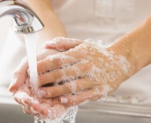 Woman washing hands with soapy water
